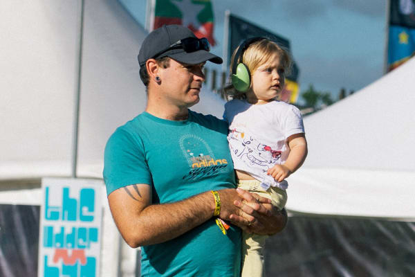 Festival-goer holding his daughter, Home Farm Fest 2026