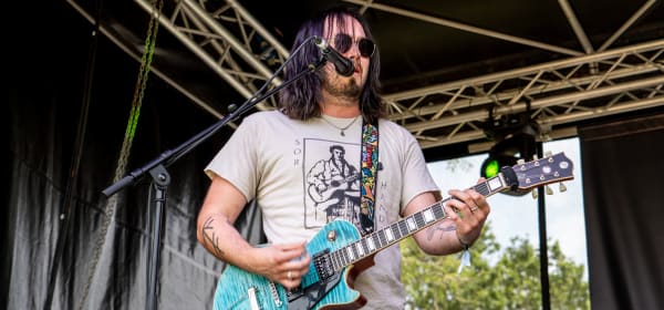 Home Farm Fest 2026 — bass player on stage, festival photography Somerset
