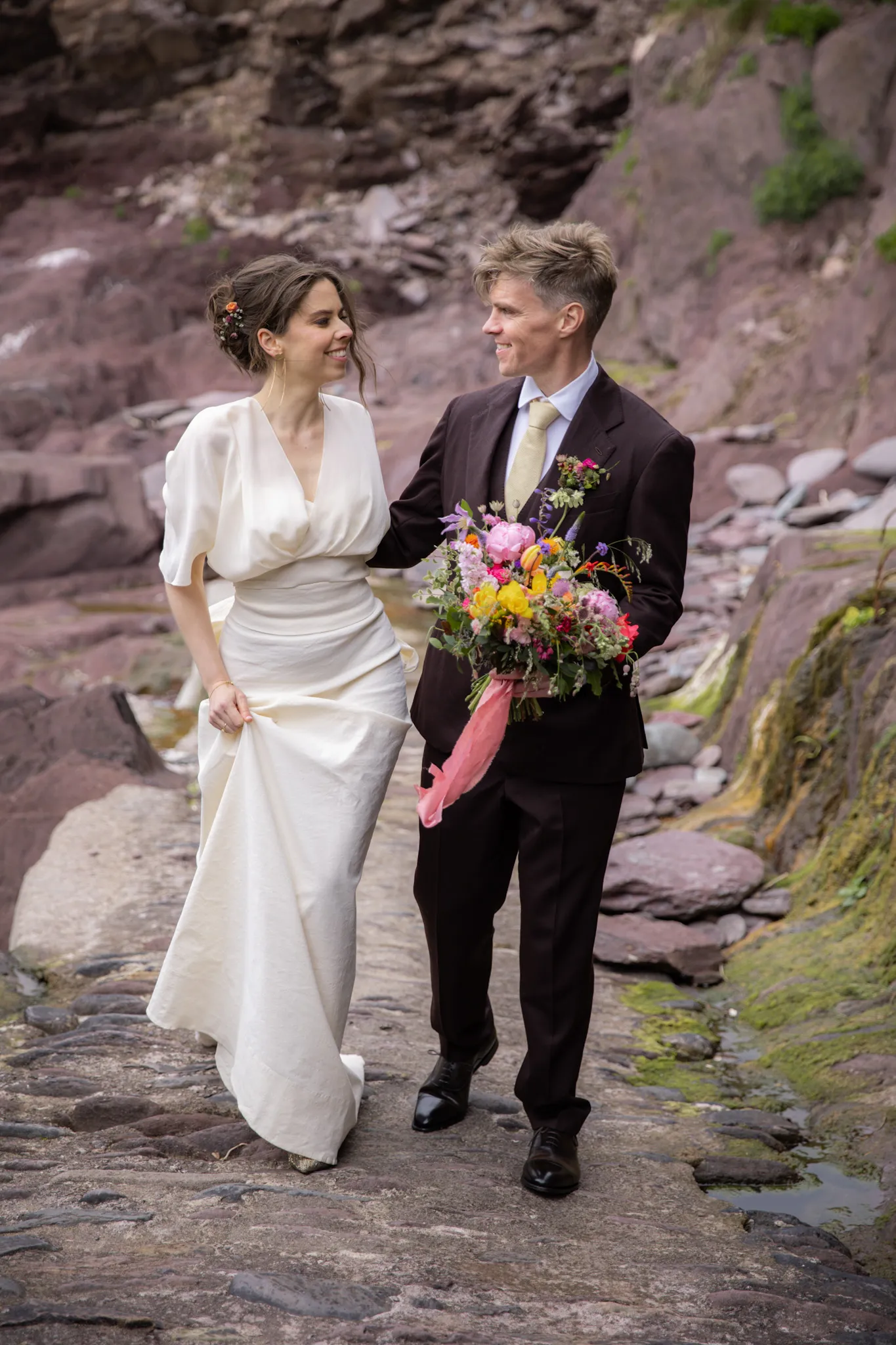 Bride and Groom walking, smiling while holding hands