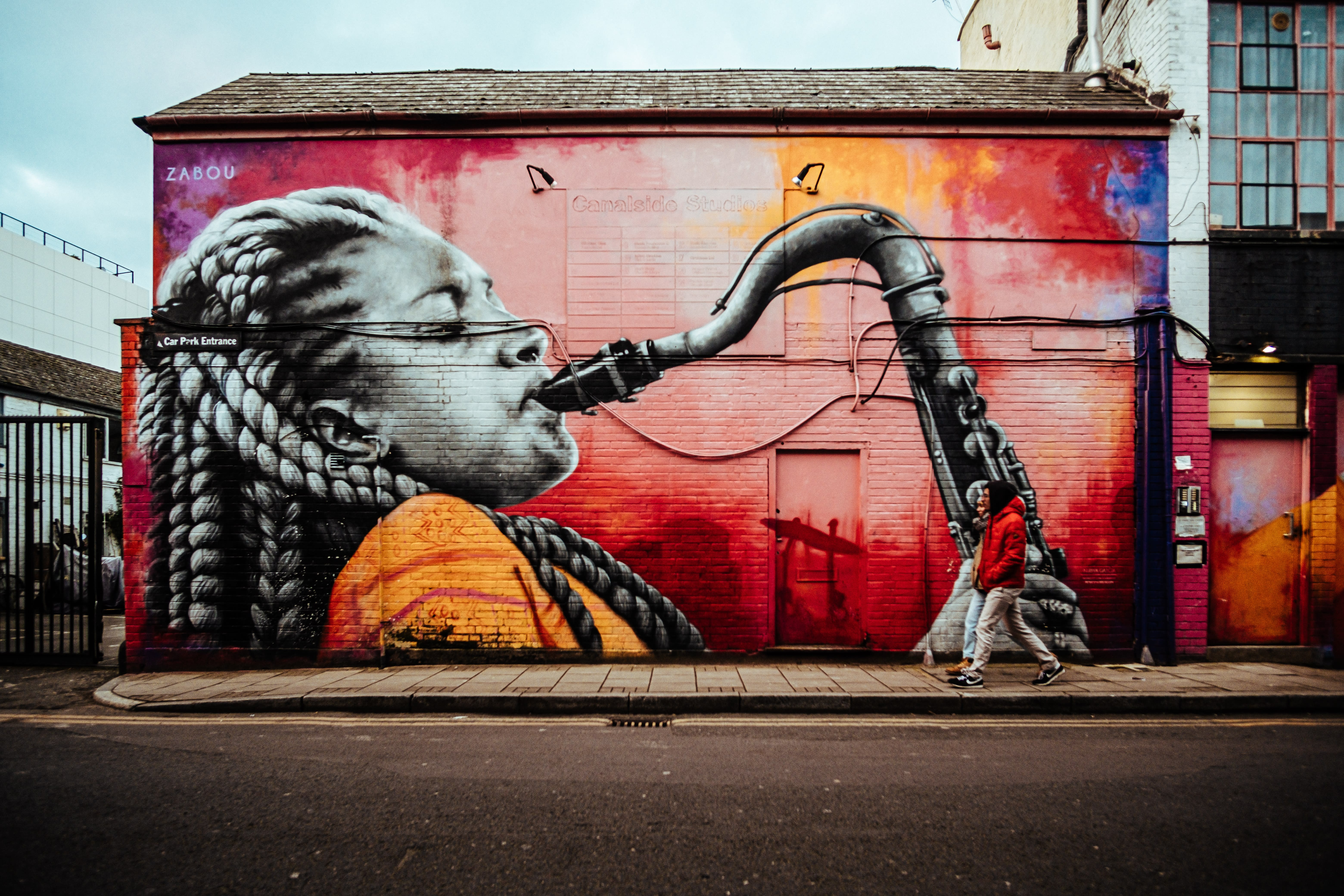 A mural on the side of a building of a girl playing a saxophone