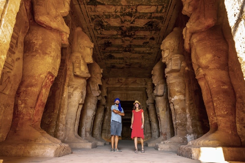 Una pareja de turistas en el Templo de Abu Simbel junto a las esculturas, en el sur de Egipto en Nubia junto al lago Nasser.