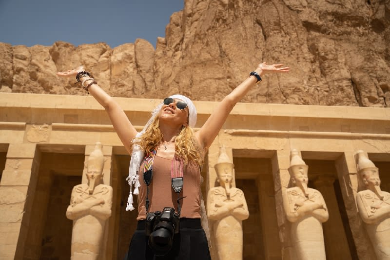 Fotógrafa de vacaciones con cámara frente al increíble Templo de la Reina Hatshepsut, Luxor, Egipto