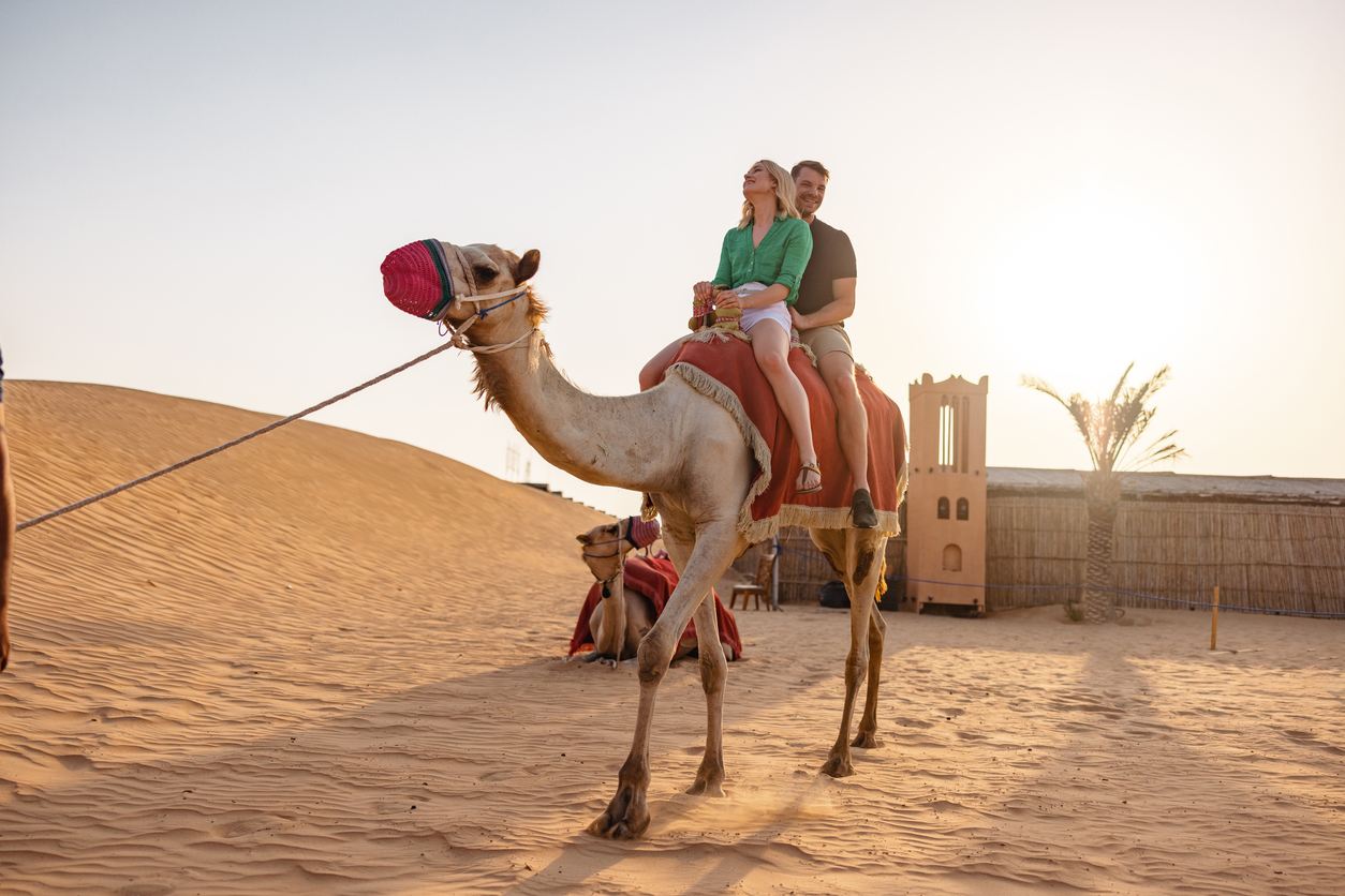 Pareja tomándose un selfie en un camello en el desierto 1
