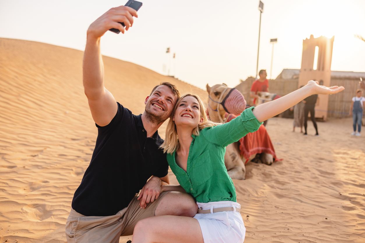 Pareja tomándose un selfie en un camello en el desierto 2