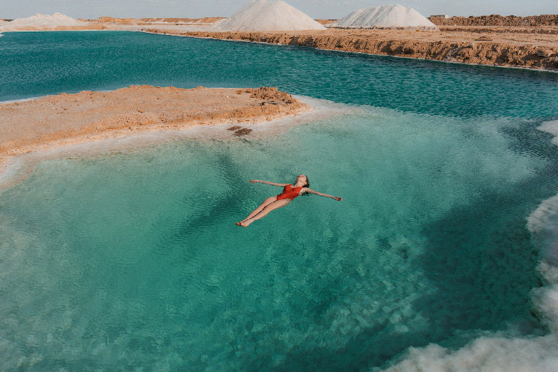 Mujer nadando en el lago salado en el oasis de Siwa