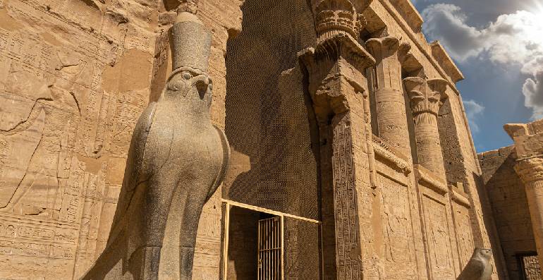 Antigua estatua de Horus y relieves del templo de Edfu en Edfu, Egipto.