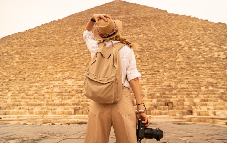 Mujer tomando fotografías frente a las emblemáticas Pirámides de Egipto