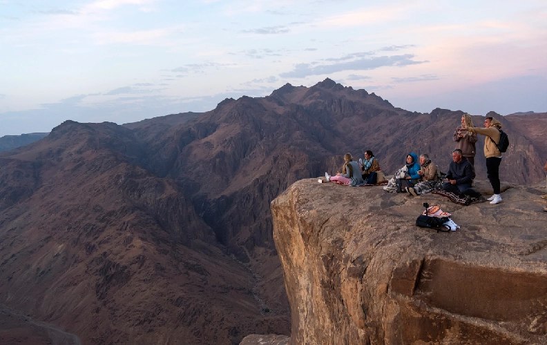 Turistas observando el amanecer desde el Monte Sinaí en Egipto