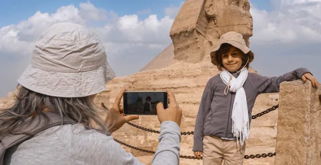 mamma fotografa il figlio davanti alla sfinge di giza, egitto natale clima