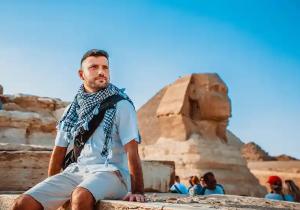Tour Cairo durante lo Scalo Aeroporto, un uomo davanti alla sfinge