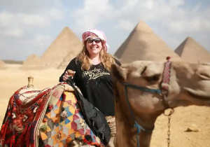 Cammellata alle Piramidi di Giza, una donna dietro un gruppo dei cammelli