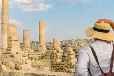 ragazza giovane con cappello in piedi a guardare il tempio di ercole nella cittadella di amman,  viaggio in giordania cosa mettere in valigia