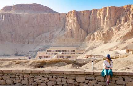 Escursione Tempio di Habu e Tombe dei Nobili, Una donna siede davanti al tempio hatshepsut
