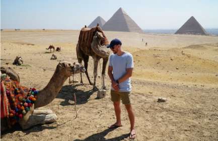 Escursione da Hurghada al Cairo in aereo, un uomo accanto a due cammelli alle piramidi