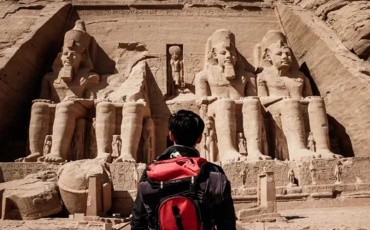 un uomo davanti il tempio di abu simbel ad assuan , egitto a dicembre