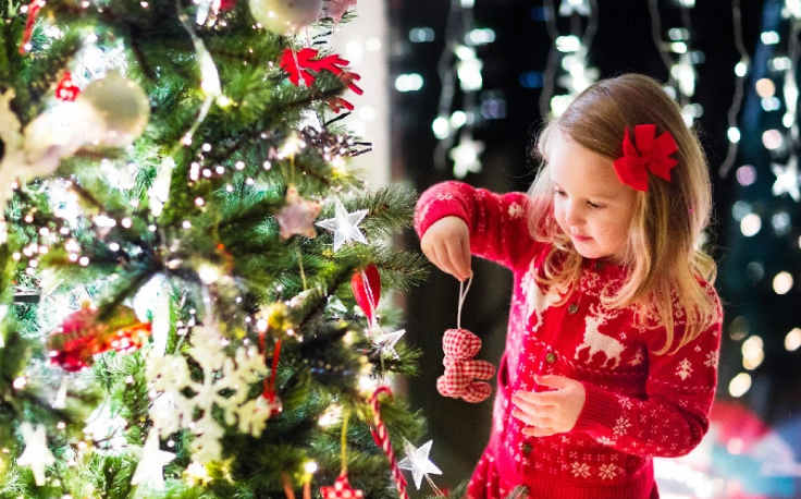 Dove andare a Natale, una ragazza accanto al albero di Natale