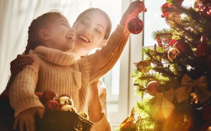 Dove andare a Natale, una madre con la sua raggazza accanto al albero di Natale