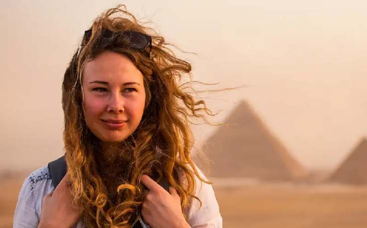 Egitto Agosto, una donna adavanti alle tre piramidi