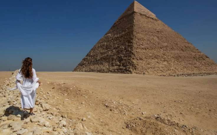 piramidi di giza altezza, una donna indossa un vestito binco alle piramidi