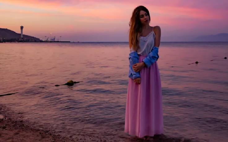 una ragazza cammina sulla spiaggia