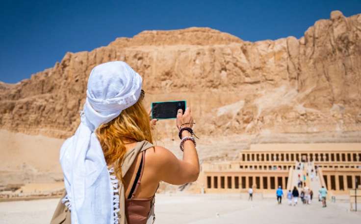 donna che scatta una foto al tempio della regina hatshepsut, egitto farnesina