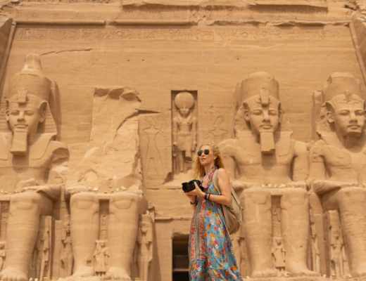 a woman standing infront of abu simble temple 