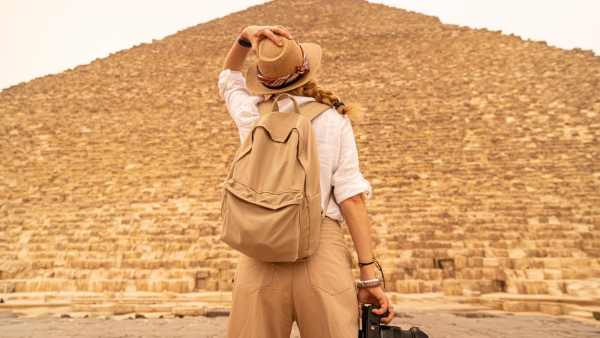 Female Tourist standing in front of the great Pyramids, Egypt Package