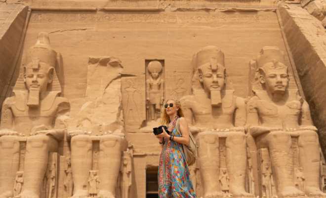 a woman standing infront of abu simble temple 
