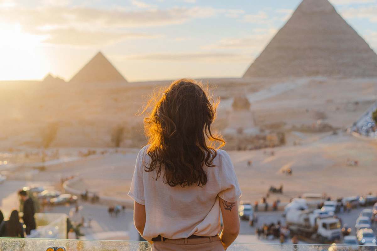 a girl standing infront of of pyramids in Giza