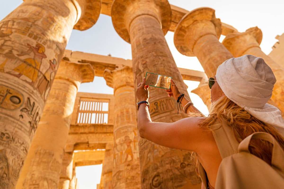 a tourist walks between pillars of the great hypostyle hall, Cairo Luxor tour