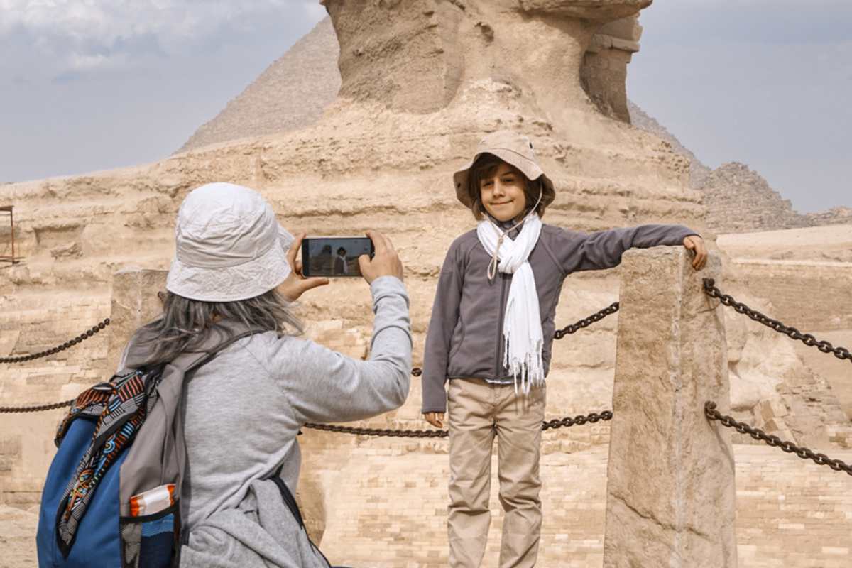 Tourist taking a picture of her son in front of the great sphinx of giza, Port Said to Cairo