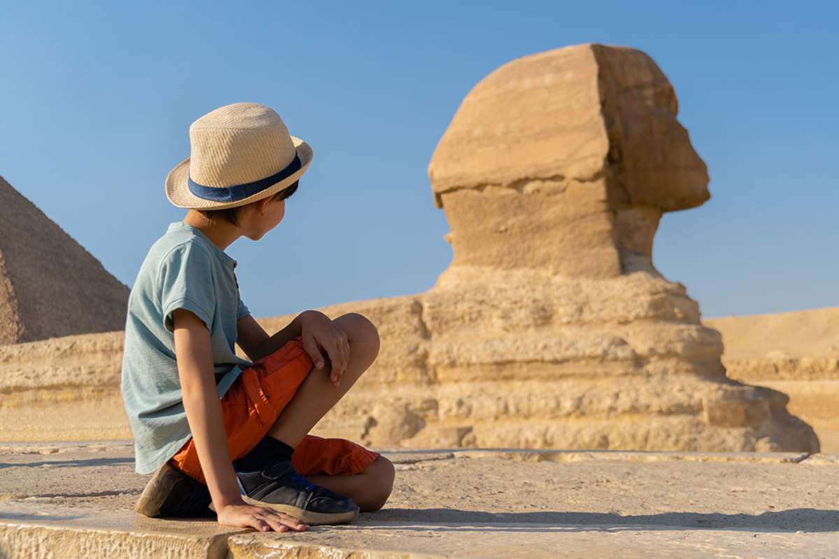 a kid taing picture by Sphinx in Giza, Cairo and Luxor Tour by Sleeper Train