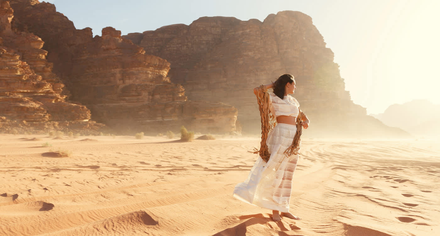 a woman in white dress in wadi rum