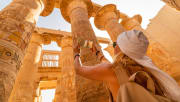 a tourist walks between pillars of the great hypostyle hall, Cairo Luxor tour