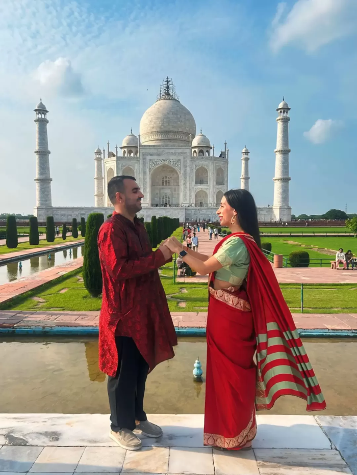 A couple taking pictures by Taj Mahal in one of our India tour packages