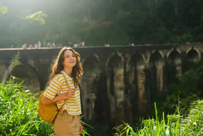 Happy woman at Nine Arch Bridge in Sri Lanka, enjoying the sunset.