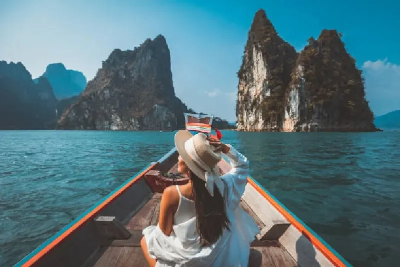 Asiatische Reisende entspannt auf einem Longtail-Boot am Ratchaprapha-Staudamm im Khao Sok Nationalpark in Thailand