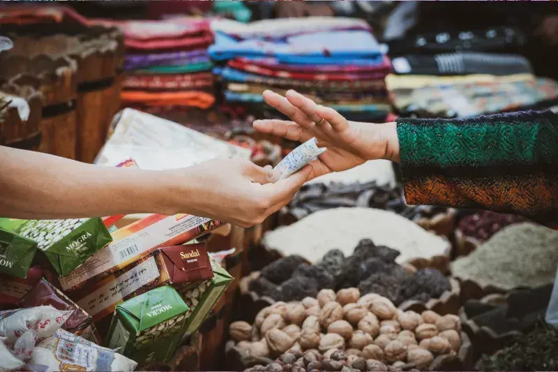 Touristen und Einheimische beim Einkaufen auf einem traditionellen Basar in Kairo, Ägypten, mit bunten Waren, Souvenirs und regionalen Produkten in den Marktständen.