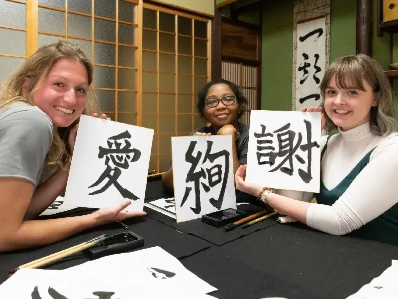 Extranjeros aprendiendo caligrafía japonesa.