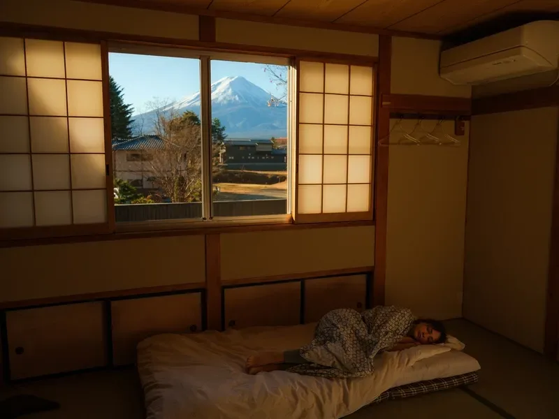 pessoa-descansando-em-quarto-tradicional-de-ryokan-japones-com-vista- ao-monte-fuji