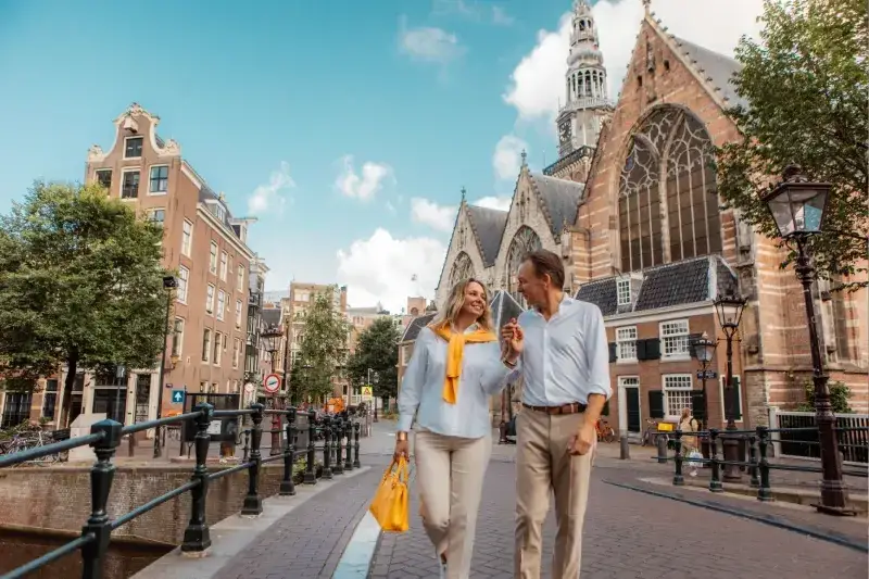 Mittelaltes Paar erkundet die Stadt Amsterdam und genießt die Sehenswürdigkeiten entlang der Grachten.