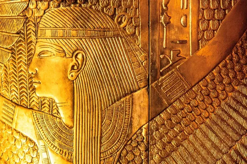 Dettaglio in oro del secondo sarcofago di Tutankhamon con la dea alata Iside in rilievo.