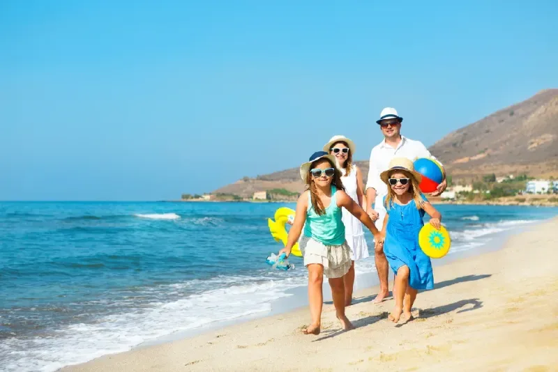 familia-joven-feliz-corriendo-y-divirtiendose-en-la-playa-al-atardecer