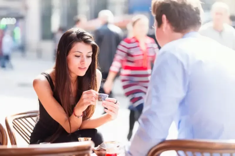 A young sensual Turkish woman is fortune telling to her boyfriend with Turkish Coffee. She is holding a traditional Turkish coffee cup