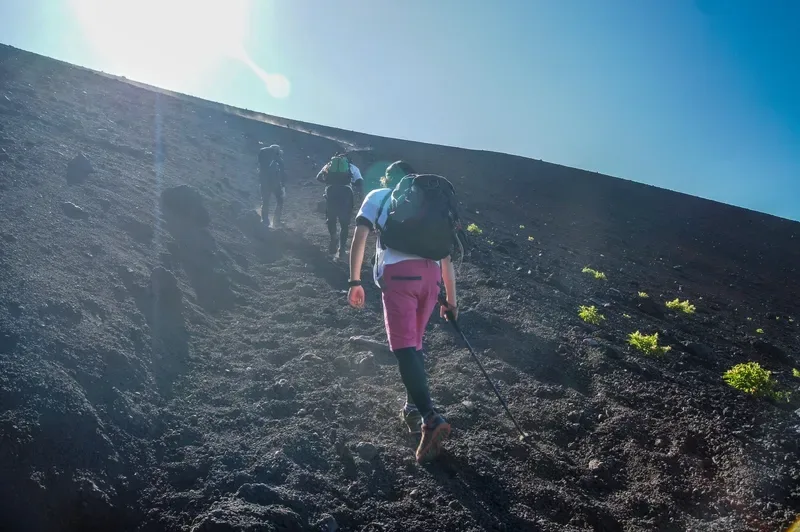 montanhistas-subindo-trilha-de-terra-vulcanica-no-monte-fuji-sob-sol-forte