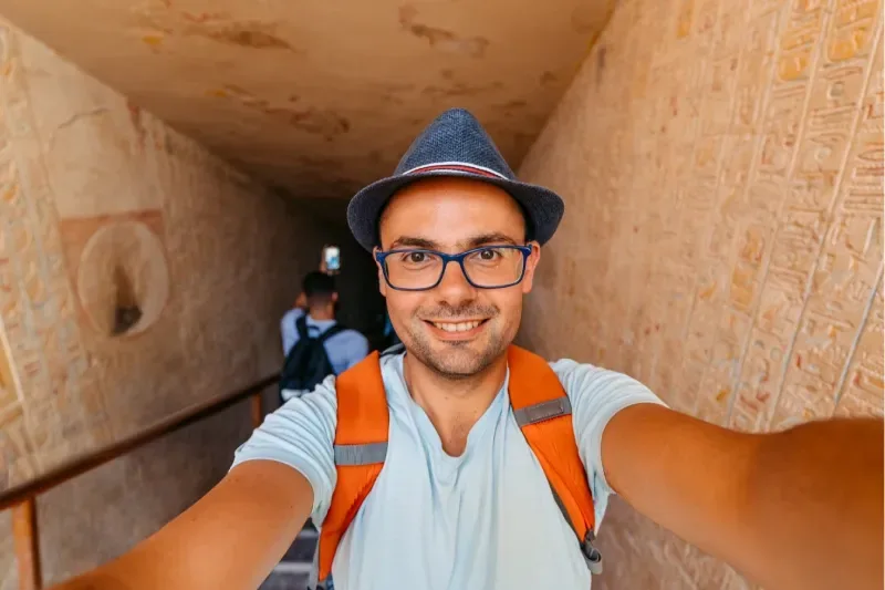 Un uomo di mezza età si scatta dei selfie con il cellulare nella Valle dei Re a Luxor, in Egitto.
