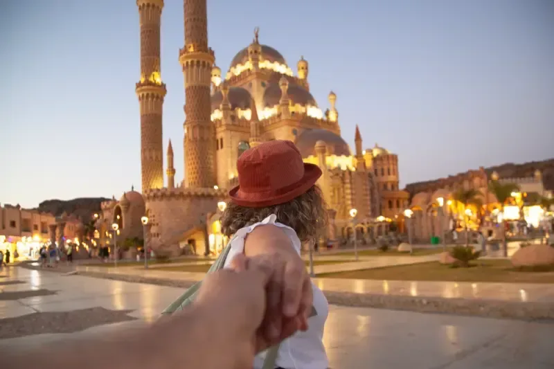 Una turista felice con lo zaino in spalla si scatta un selfie davant Moschea Al Sahaba a Sharm El Sheikh.
