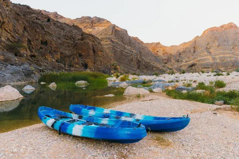 Two blue kayak boats by the river in Wadi Al Arbeieen 