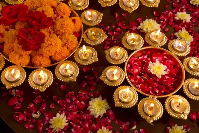 Un arreglo de pétalos de rosa con lámparas de aceite tradicionales para la celebración del festival de Diwali.