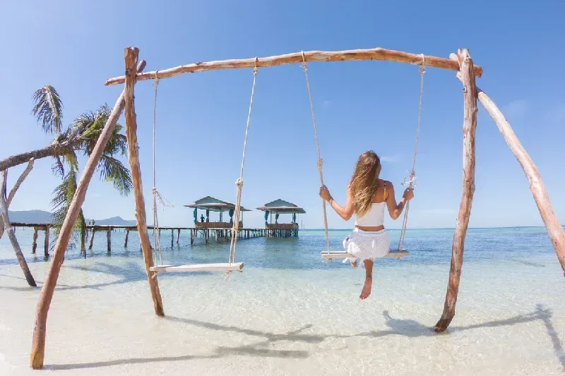 A woman on a swing overlooking a beautiful beach in Vietnam